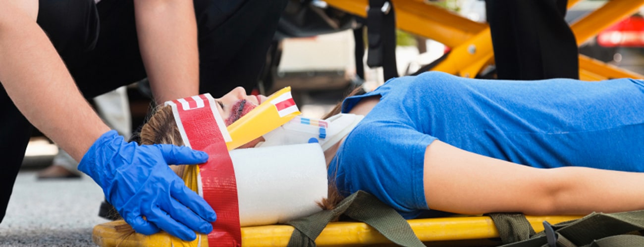 Paramedics strapping a wounded woman